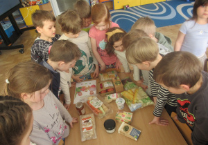 Dzieci oglądają produkty ze znaczkiem ekologicznym.