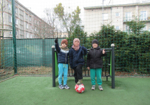 Chłopcy pozują do zdjęcia na boisku przedszkolnym.