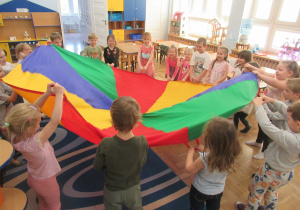 Dzieci trzymają chustę animacyjną.