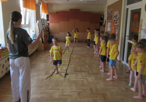 Dzieci ćwiczą na zajęciach gimnastycznych z elementami taekwondo.