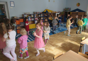 Dzieci maszerują w dwóch kołach z instrumentami.