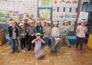 Dzieci pozują w zdjęcia w opaskach wykonanych na zajęciach.