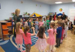 Dzieci z panią stoją w kole.