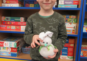 Chłopiec prezentuje wykonanego na warsztatach zajączka.