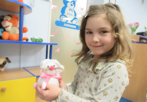 Dziewczynka pozuje do zdjęcia z zajączkiem wykonanym na warsztatach.