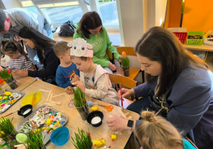 Dzieci i ich rodzice wykonują świąteczne ozdoby