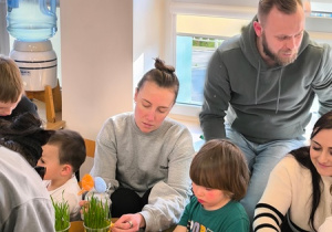 Dzieci i ich rodzice wykonują świąteczne ozdoby