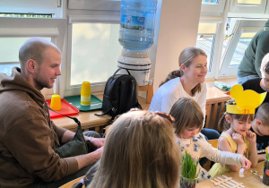 Dzieci i ich rodzice wykonują świąteczne ozdoby