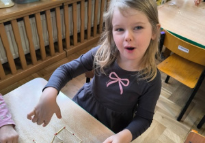 Dziewczynka układa wzór z zapałek