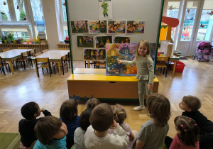 Dziewczynka wskazuje postać znajdującą się na plakacie