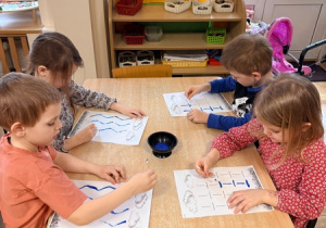 Dzieci malują szlaczek za pomocą patyczka higienicznego