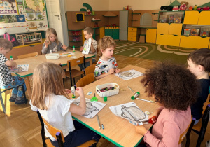 Dzieci wycinają obrazki przedstawiające składniki marcowej pogody