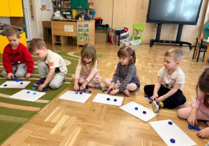 Dzieci liczą nakrętki udające kropelki deszczu