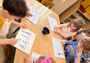 Dzieci malują palcami kropelki deszczu