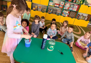 Dziewczynka miesza wodę z niebieską farbą