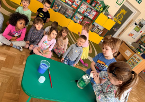 Dziewczynka z chłopcem wyciskają piankę do golenia do słoika wypełnionego wodą