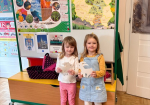 Dziewczynki trzymają sylwety koziołków poznańskich