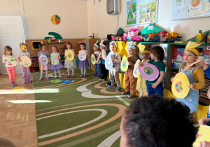 Dzieci - podczas występu dla rodziców - stoją w półkolu i trzymają sylwety pisanek