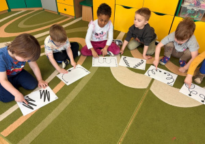 Dzieci wodzą palcami po wzorach