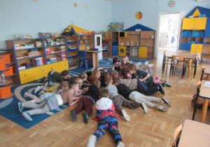 Dzieci leżą na dywanie podczas zajęć Roar Dance.