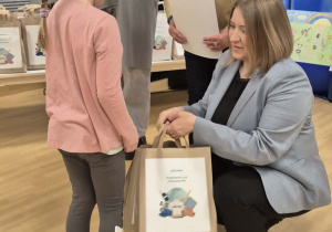 Dziewczynka odbiera nagrodę za udział w konkursie plastycznym "Kim będę jak dorosnę?".