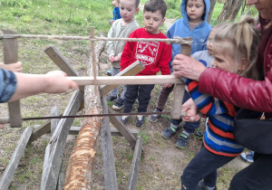 Dzieci próbują swoich sił podczas piłowania drewna