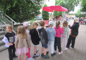 Dzieci stoją w kolejce po lody.