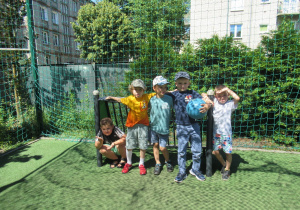 Chłopcy pozują do zdjęcia na boisku w ogródku przedszkolnym.