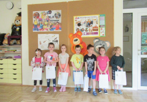 Uczestnicy konkursu fotograficznego "Cyfry z natury" pozują do zdjęcia z upominkami.