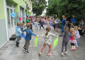 Dzieci tańczą w kole krakowiaka podczas Pikniku Rodzinnego.