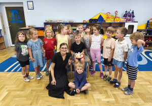 Dzieci i pani pozują do zdjęcia podczas świętowania urodin chłopca.