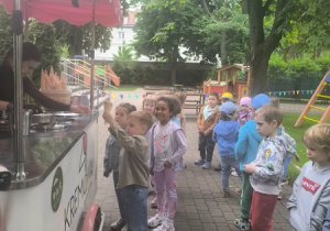 Dzieci stoją w kolejce po lody