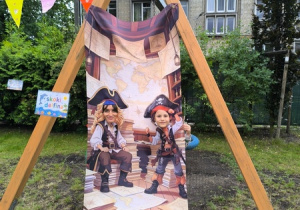 Chłopiec pozuje do zdjęcia przy płachcie przedstawiającej pirata
