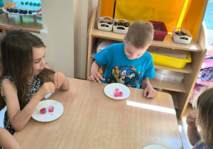 Dzieci jedzą lody zrobione z soku