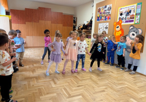 Chłopcy grają na instrumentach, dziewczynki tańczą