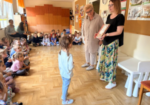 Dziewczynka odbiera nagrodę, którą otrzymała za udział w wyzwaniu czytelniczym