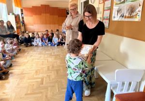 Chłopiec odbiera nagrodę, którą otrzymał za udział w wyzwaniu czytelniczym