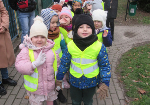 Dzieci stoją w parach przed budynkiem przedszkola.