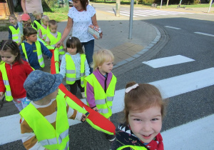 Przedszkolaki przechodzą przez przejście dla pieszych.