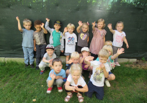 Dzieci pozują do zdjęcia w ogródku przedszkolnym.