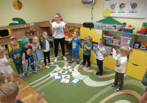 Dzieci stoją w kole podczas zajęć z języka angielskiego.