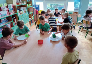 Dzieci nalewają wodę do talerzy