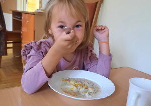 dziewczynka zajada pyszną zupkę