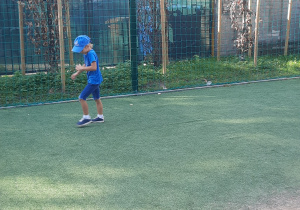 dziewczynka gra w piłkę na boisku przedszkolnym