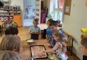 dzieci wykonują pizzę podczas zajęć o Włoszech