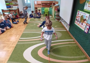 Dzieci chodzą po sznurku uformowanym w kształt cyfry 1