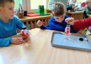 Dzieci wsypują brokat do butelki z wodą