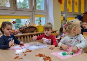 Dzieci siedzą przy stolikach i wykonują pracę plastyczną: "Włoskie lody".