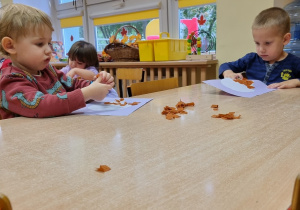 Dzieci siedzą przy stolikach i wykonują pracę plastyczną: "Włoskie lody".