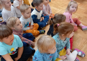 Dzieci siedzą i słuchają koncertu.